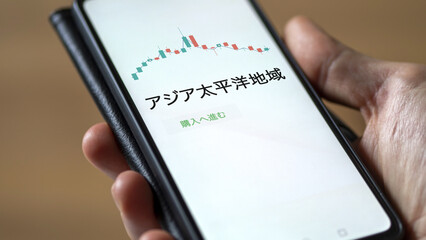 Investor analyzing an ETF. Funds stocks exchange ETFs Japanese text: Asia Pacific, buy. アジア太平洋地域 証券取引所 投資 shares