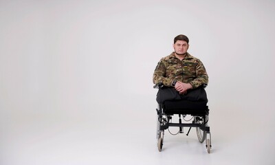 Plakat man in camouflage uniform soldier sitting in wheelchair and smiling at camera having rehabilitation copy space Russia attacked Ukraine