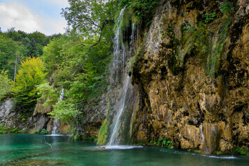 Fototapeta na wymiar Plitvice, Croatia: View of the beautiful waterfalls of Plitvice Lakes in Plitvice National Park. Green foliage and turquoise water