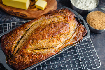 Freshly Baked Banana Bread in Loaf Pan: Banana bread in a nonstick pan on a wire cooling rack