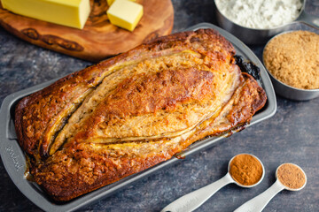 Freshly Baked Banana Bread in Loaf Pan: Banana bread in a nonstick pan with Ingredients in the Background