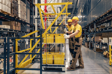 Smiling warehouse workers preparing a shipment in a large warehouse