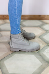 Close-up female legs in jeans and leather grey boots. New spring-summer collection of women leather shoes.