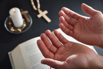 Christian praying with open hands up and christian elements