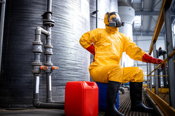 Work injury. Factory worker in chemicals production plant having a back pain due to heavy lift.
