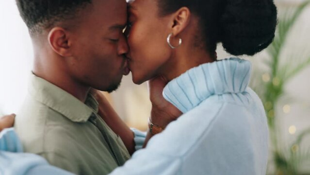 Couple kiss, African marriage and happy in house, smile for love and dancing together in living room of home. Black man and woman kissing in the lounge with a dance in happiness in apartment