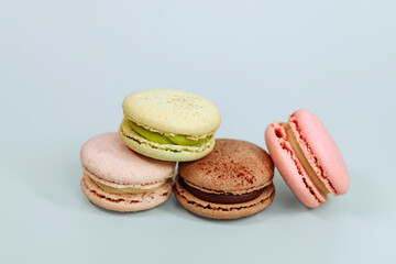 Sweet macaroons in pastel colors isolated on blue background. Delicious beautiful macaroons.