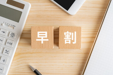 早割と書かれたブロック、電卓、スマホ、ノート、ペン