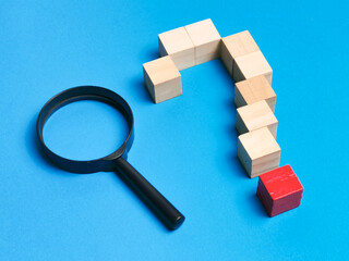 Wooden cubes arrange as question mark symbol with magnifying glass. Question mark concept.