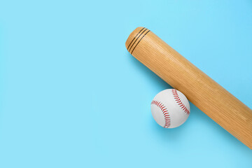 Obraz na płótnie Canvas Wooden baseball bat and ball on light blue background, flat lay. Space for text