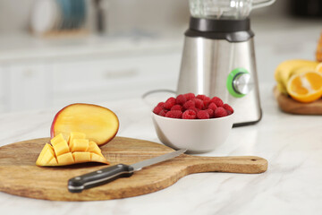 Cut mango and raspberry on white marble table. Ingredients for smoothie