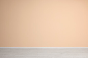 Empty room with beige wall and wooden floor