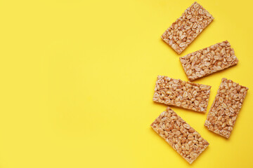 Tasty peanut bars (kozinaki) on yellow background, flat lay. Space for text