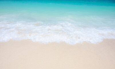 Fototapeta na wymiar Light blue sea waves on clean sandy beach.
