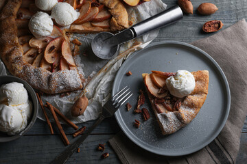 Delicious apple galette with ice cream and pecans on wooden table, flat lay