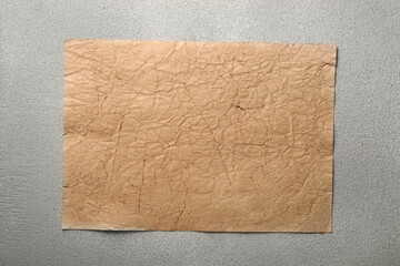Sheet of old parchment paper on light gray textured table, top view