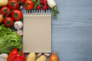 Blank recipe book and different ingredients on grey wooden table, flat lay. Space for text