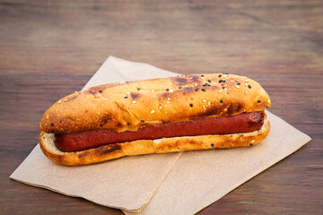 Fresh tasty hot dog on wooden table, closeup