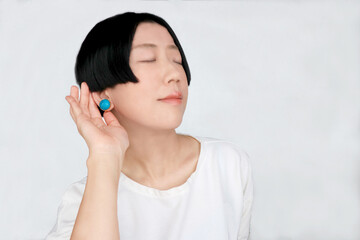 耳を澄ませる黒髪ショートヘアの女性