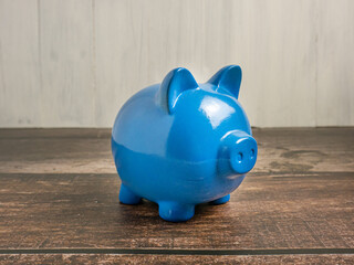 The blue piggy bank on wood table for earn or saving concept