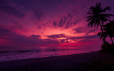 Naklejka na ściany i meble Beautiful tropical seascape, sunset at beach with colorful sky
