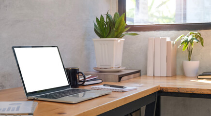 Laptop computer with blank screen, coffee cup on table Comfortable workplace..