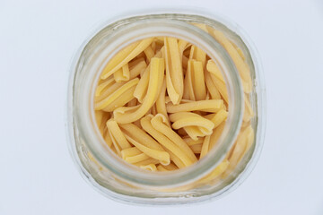 Italian macaroni inside of a glass jar viewed from above. 