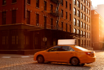 Yellow taxi cab passing through Tribeca in New York City.