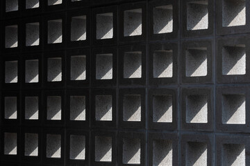 A sunlit design block wall viewed from inside the building. Q block