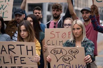 Fototapeta na wymiar Multiracial Students Protest Against Global Warming on Urban Street