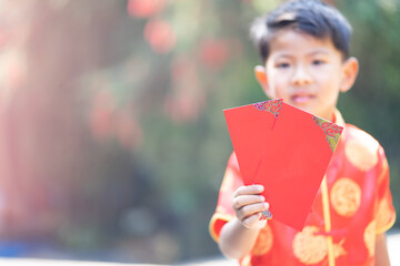 boy wearing red cheongsam holding chinese new year red envelope