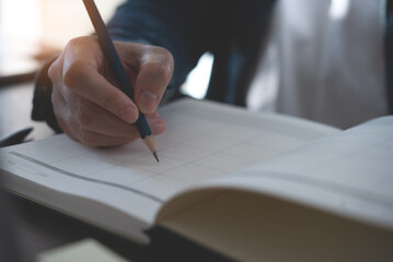 Event planner timetable agenda plan on year 2023 schedule event. Business woman checking timetable, taking note on calendar planner notebook on office table. Calendar event plan, work planning