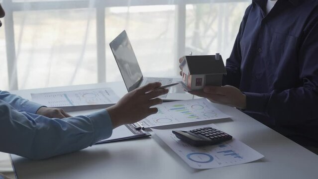 Real estate business meeting, two businessmen discussing house sale in office