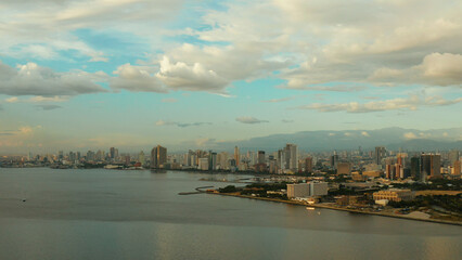 Fototapeta premium Skyscrapers and business centers in a big city Manila. Modern metropolis at sunset, top view.