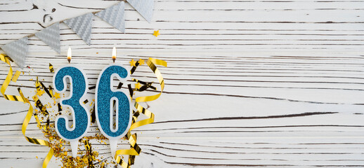Number 36 blue celebration candle on white wooden background. Happy birthday candles. Concept of celebrating birthday, anniversary, important date, holiday. Copy space.