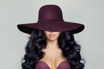 Beautiful Model Woman with Curly Hairstyle in wide purple broad brim hat