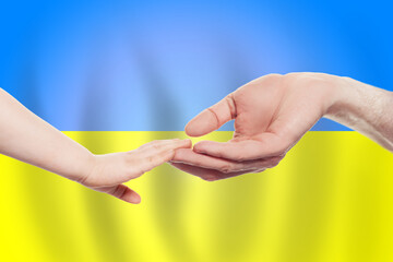 Ukrainian baby and parent hands on the background of flag of Ukraine Help, aid, support, charity concept