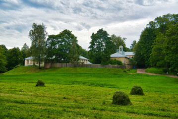 Fototapeta na wymiar Green meadow and ruins of estate in Park Mon Repos, Vyborg, Russia