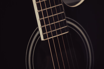 Strings on a black guitar. Close-up.