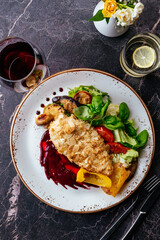 chicken schnitzel on a plate with vegetables and sauce. restaura