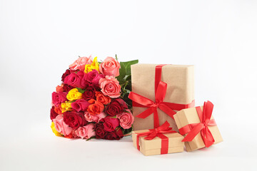 A bouquet of red roses and a gift box on the table in the interior. A declaration of love. Celebrating Valentine's Day. A birthday present.Isolated object. Copy space.