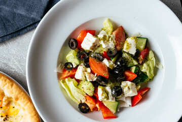 greek salad with cheese, olives, tomatoes and herbs