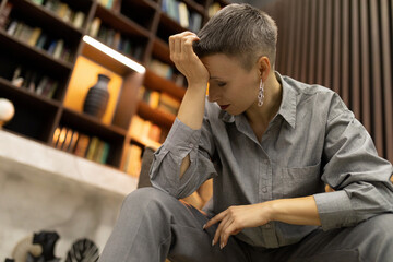 tired business lady in a white shirt sits in a company office