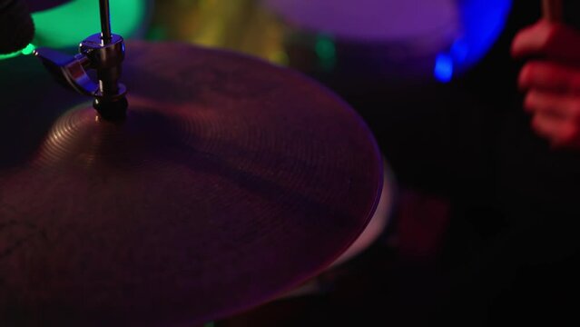 Close Up Portrait of Drummer Playing Drums, colored lights