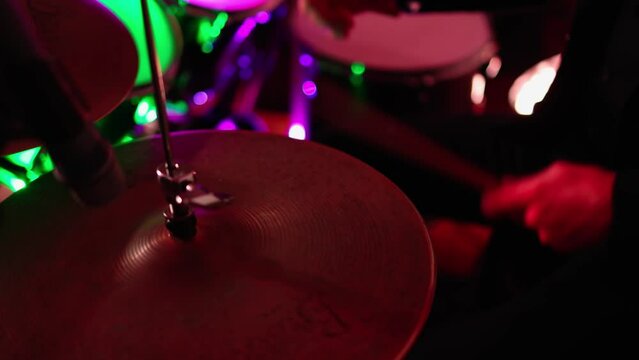 Close Up Portrait of Drummer Playing Drums, colored lights
