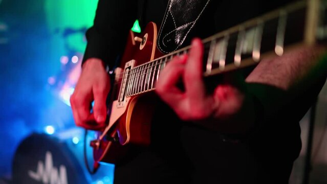 Man is playing guitar on stage.close up,Animation multicolor lights