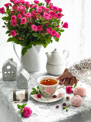 Obraz na płótnie Canvas Selective focus of delicious tea with pink baby rose flowers on white background.