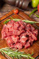 Raw fresh beef or lamb cubes. Diced red beef meat on a wood serving board. Raw casserole or stewing...