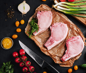 Several raw pork steaks on baking paper