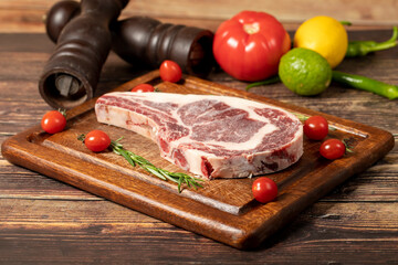 Veal chop. Fresh beef raw thick ribs with spices and rosemary. Special cutlet. wood background